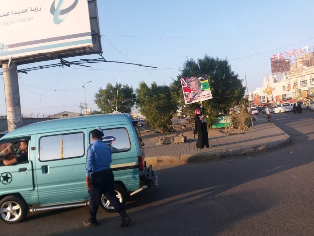 المرأة التي حيّرت الناس بعدن.. وتساؤل عن سبب رفعها صور ملكة بريطانيا منذ سنوات