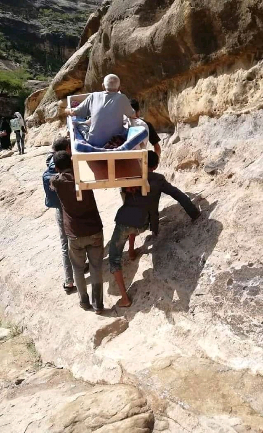 صورة لأربعة يمنيين يحملون والدهم المسن على التابوت وهو على قيد الحياة.. تعرف على قصتها